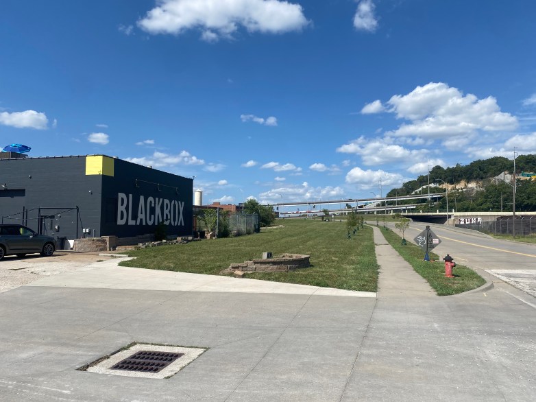 Exterior view of the BlackBox Theatre with a clear blue sky and scattered clouds.